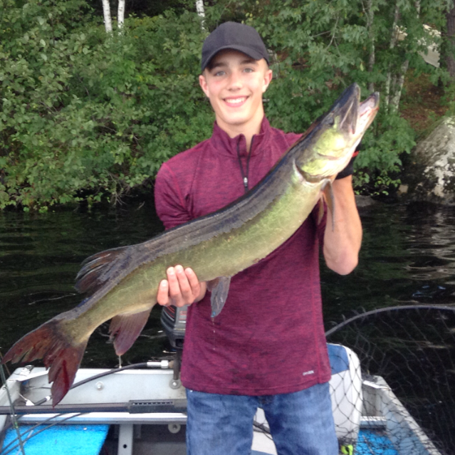 A guest holding a large musky caught on Barker Lake